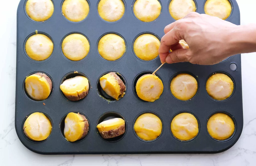 Picking the frozen mango tarts out with toothpick