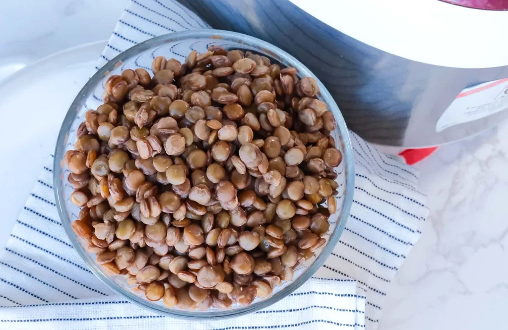 Cooked lentil rice next to a rice cooker