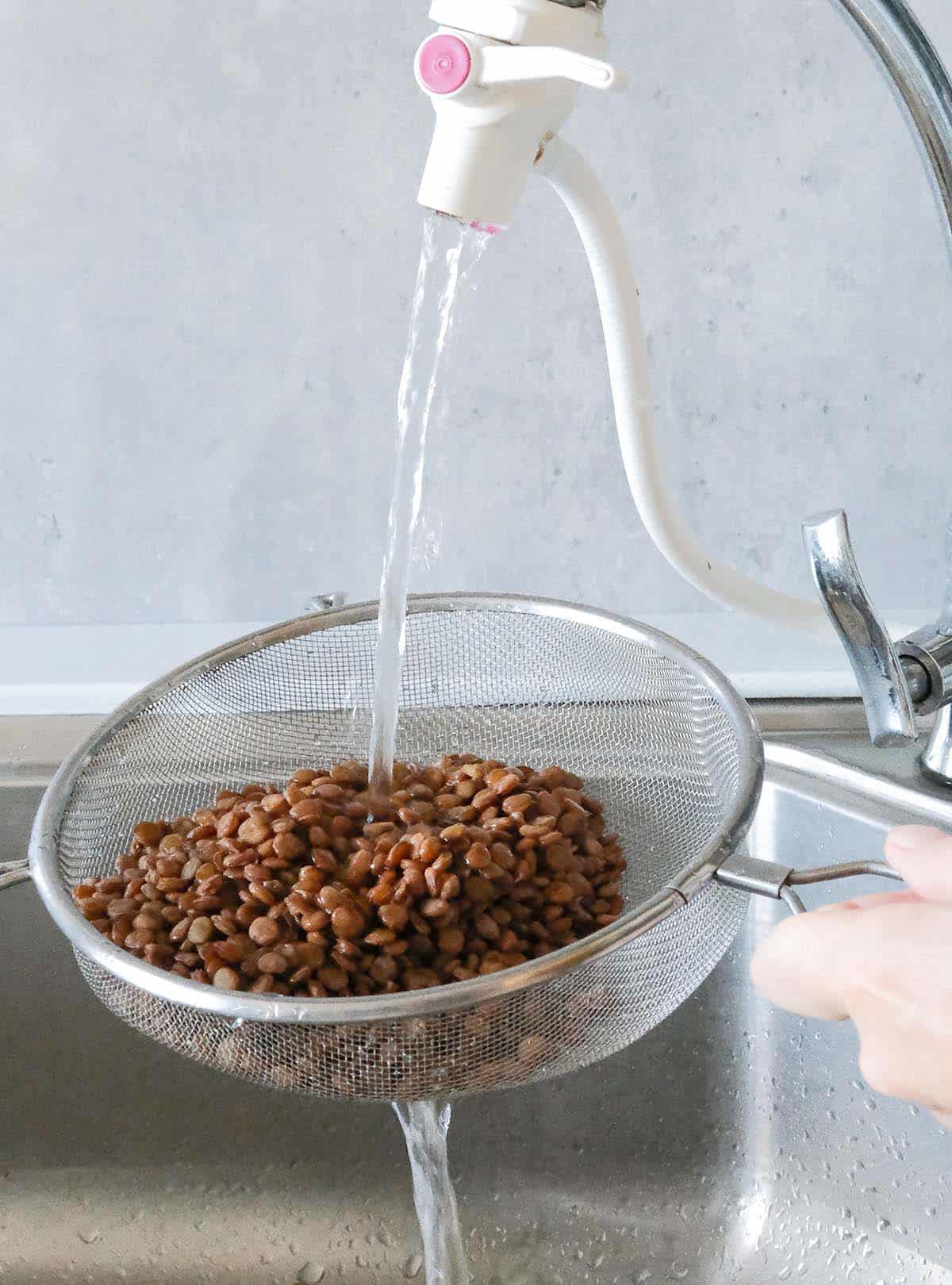 Rinsing cooked lentils with tap water