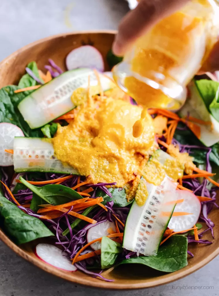 Pouring Japanese Ginger Salad Dressing onto salad