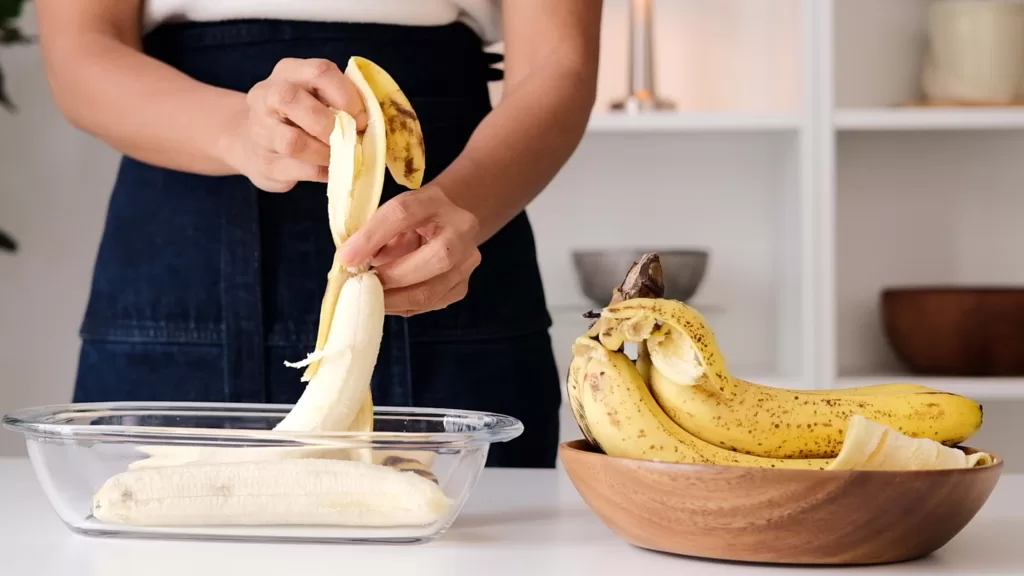 Step 2 on how to make gingerbread bundt cake: The photo shows me peeling the banana skin