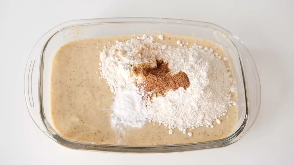 A bowl of batter with the dried ingredients in making guilt-free gingerbread bundt cake