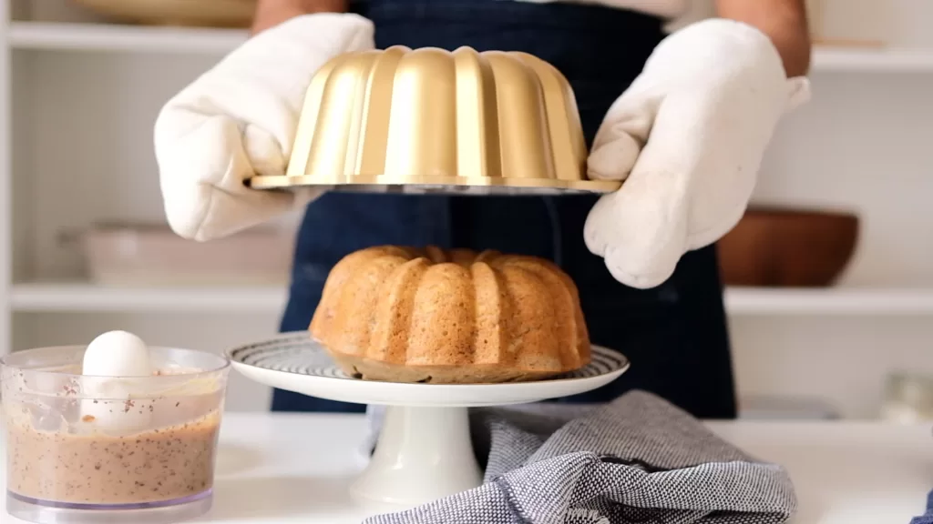 My hand revealed the freshly baked cake out of the bundt cake pan.