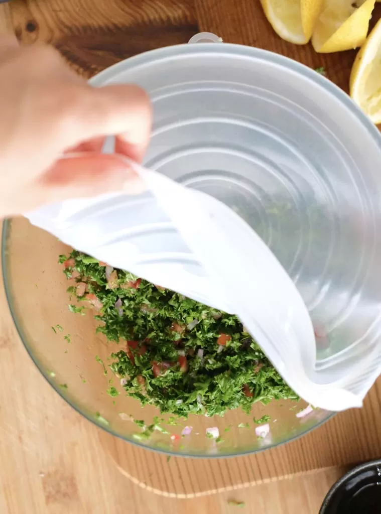 Parsley salad in a bowl, half covered by stretchable silicone bowl cover