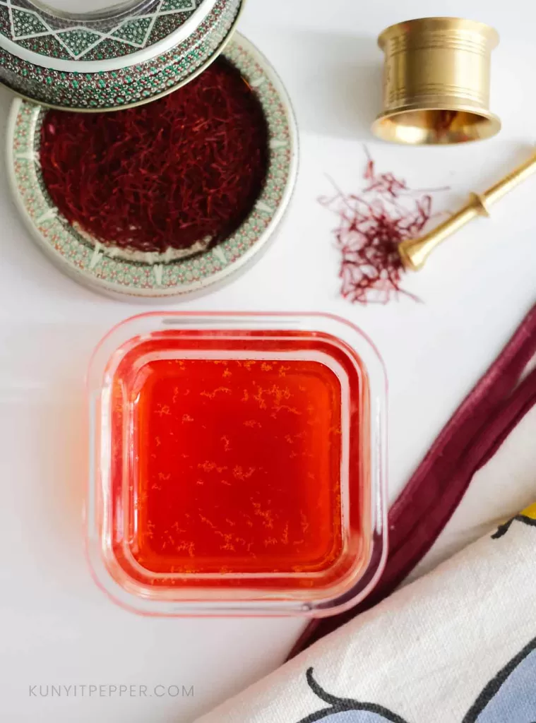 Blooming saffron water with saffron threads next to it