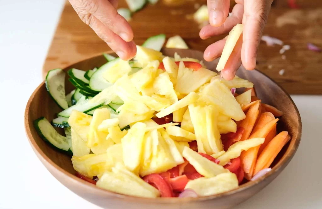 Tossing all the sliced vegetables in a salad bowl