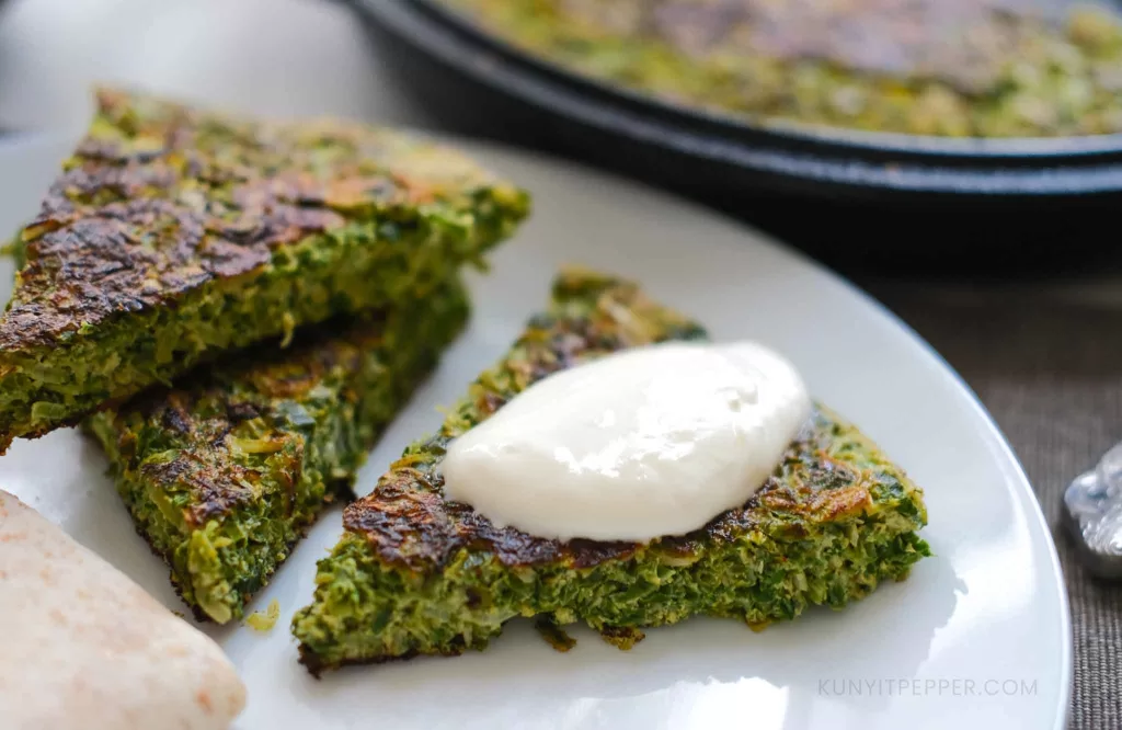 Triangular cut of leeks and chives frittata served with bread and yogurt