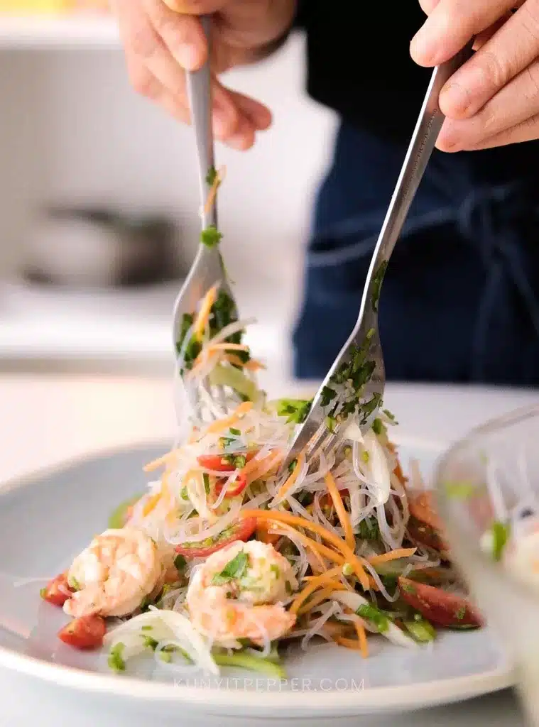 Mixing Thai Glass Noodle Salad with Celery with fork