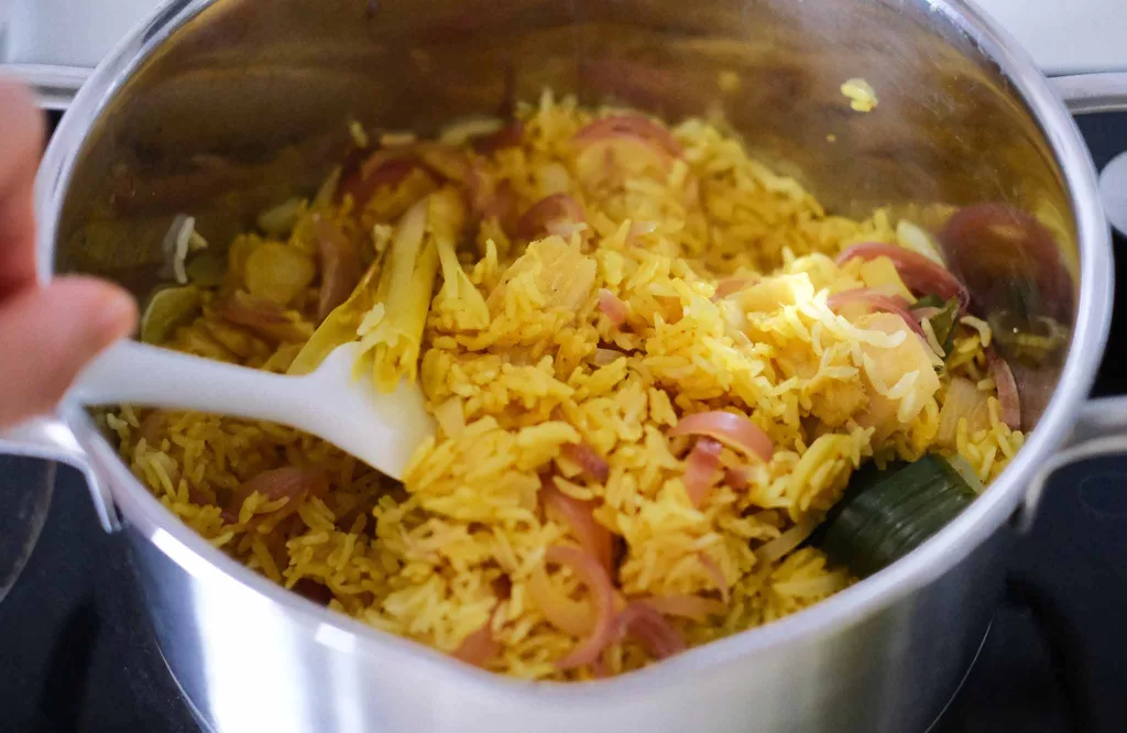 Fluffing turmeric rice in a pot