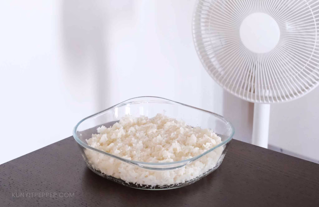 Drying steamed glutinous rice next to a fan