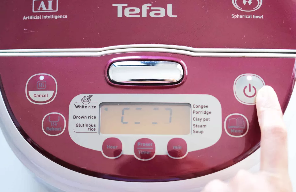 Pressing white rice setting button on rice cooker.jpg