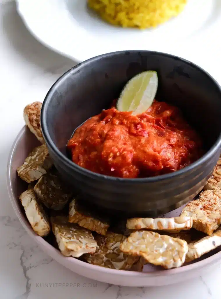 Sambal oelek/sambal ulek in a bowl next to tempeh and turmeric rice