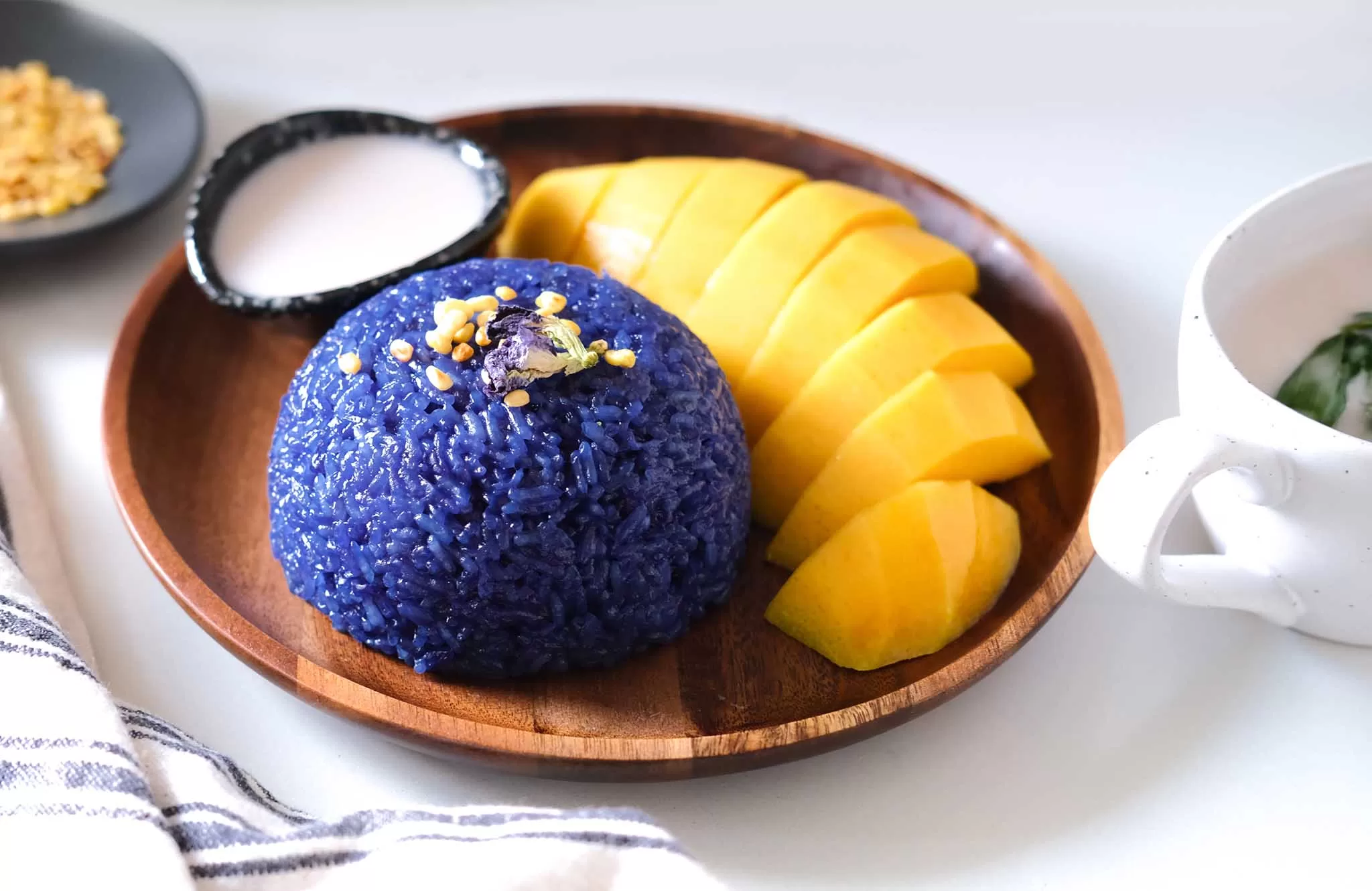 Authentic Butterfly Pea Mango Sticky Rice in a wooden plate