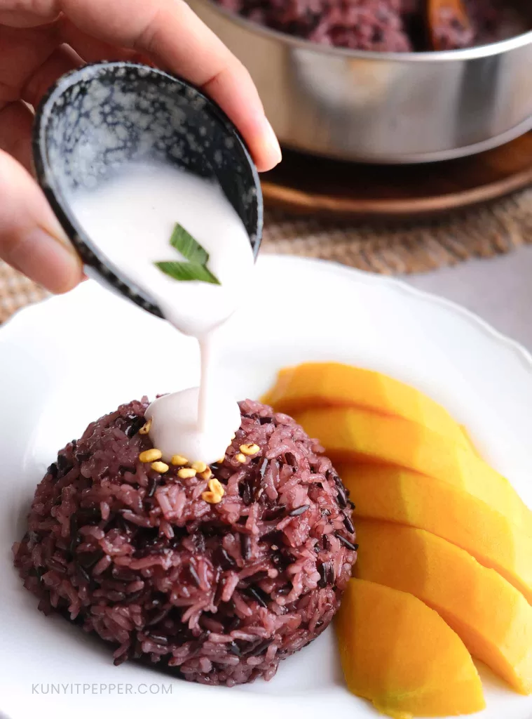 Drizzling coconut cream on Thai Mango Purple Sticky Rice