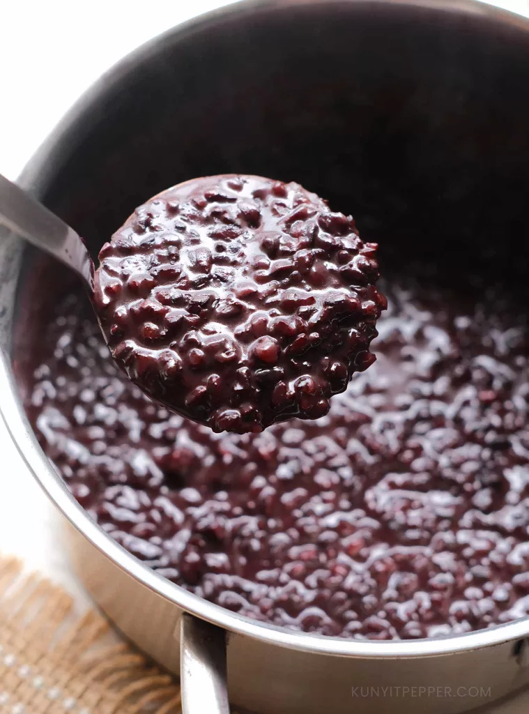 Scooping Black Sticky Rice Pudding in a pot