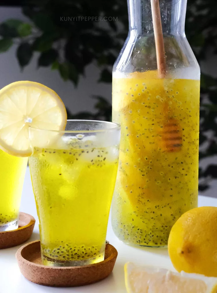Stirring Basil seed drink in a jar with honey dipper