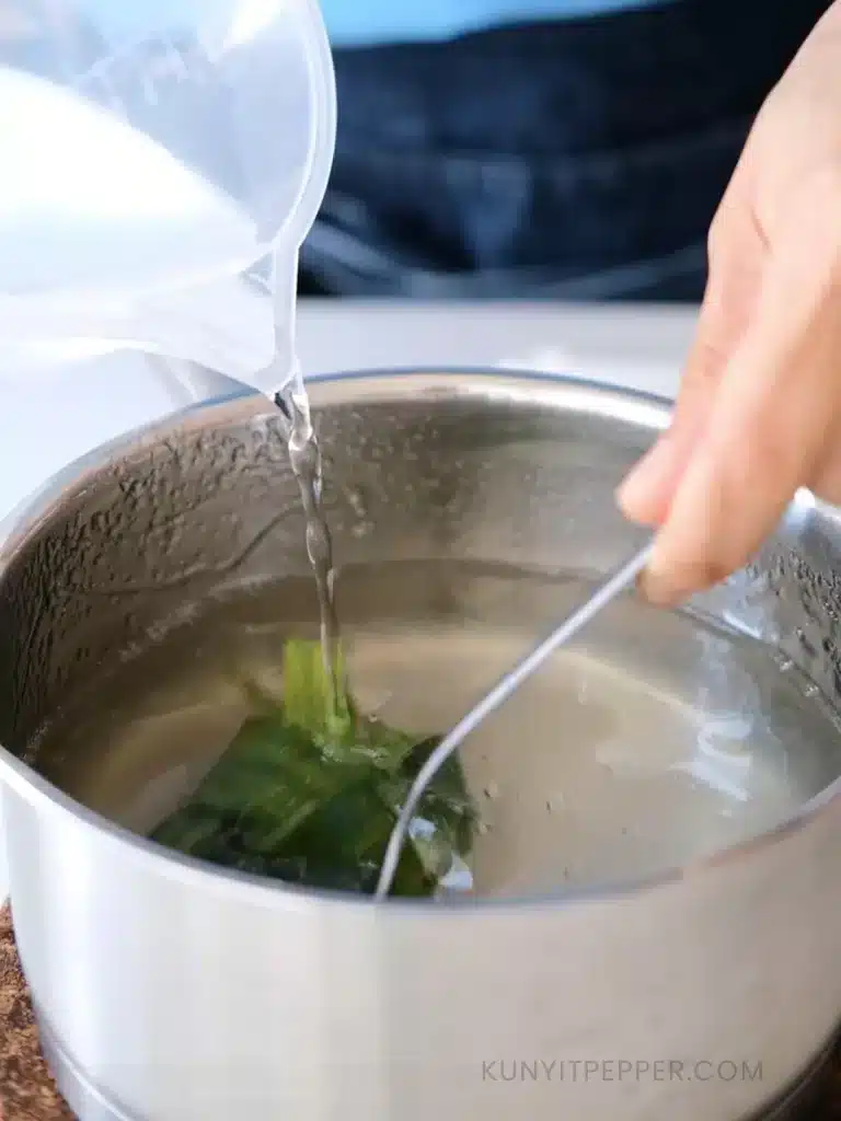 Pouring while stirring coconut water into agar-agar solution in a pot