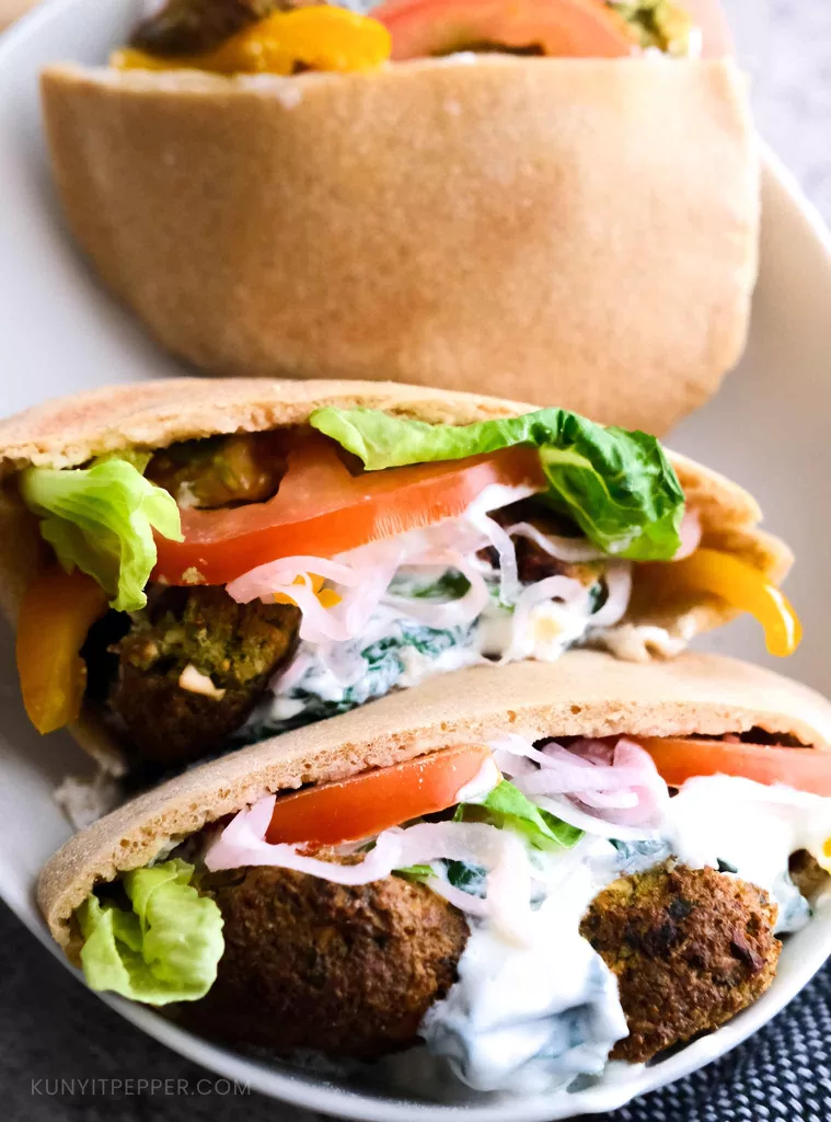 Falafel stuffed in whole wheat pita bread layered with vegetables and creamy Greek yogurt spianch dip