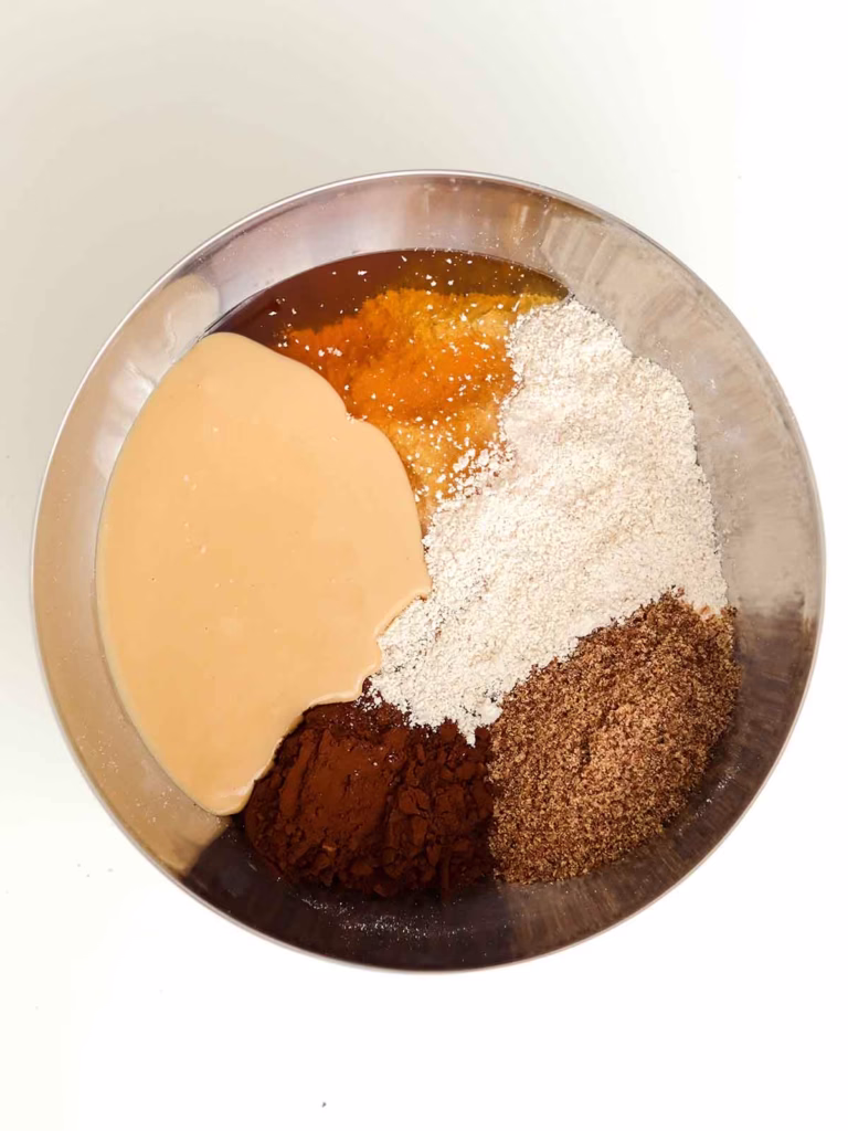 Oat flour, ground flaxseed, peanut butter, honey and cocoa powder in a bowl