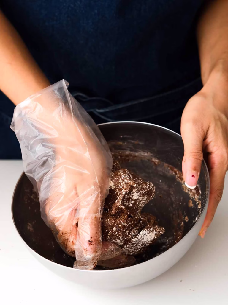 Kneading the dough with hand covered with glove